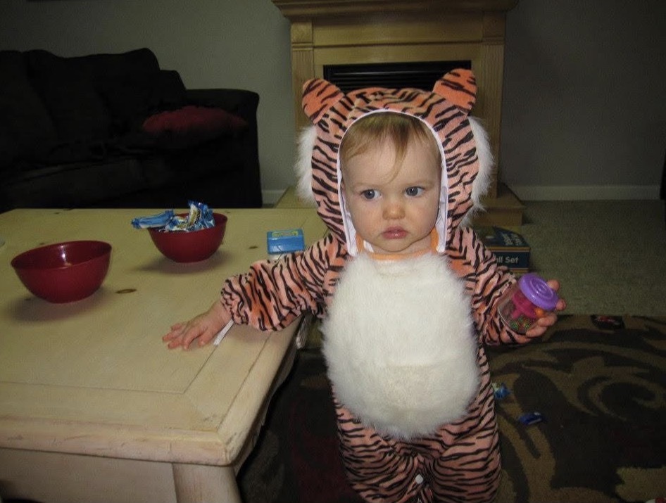 Tyler as a toddler in a tiger costume beside the family coffee table